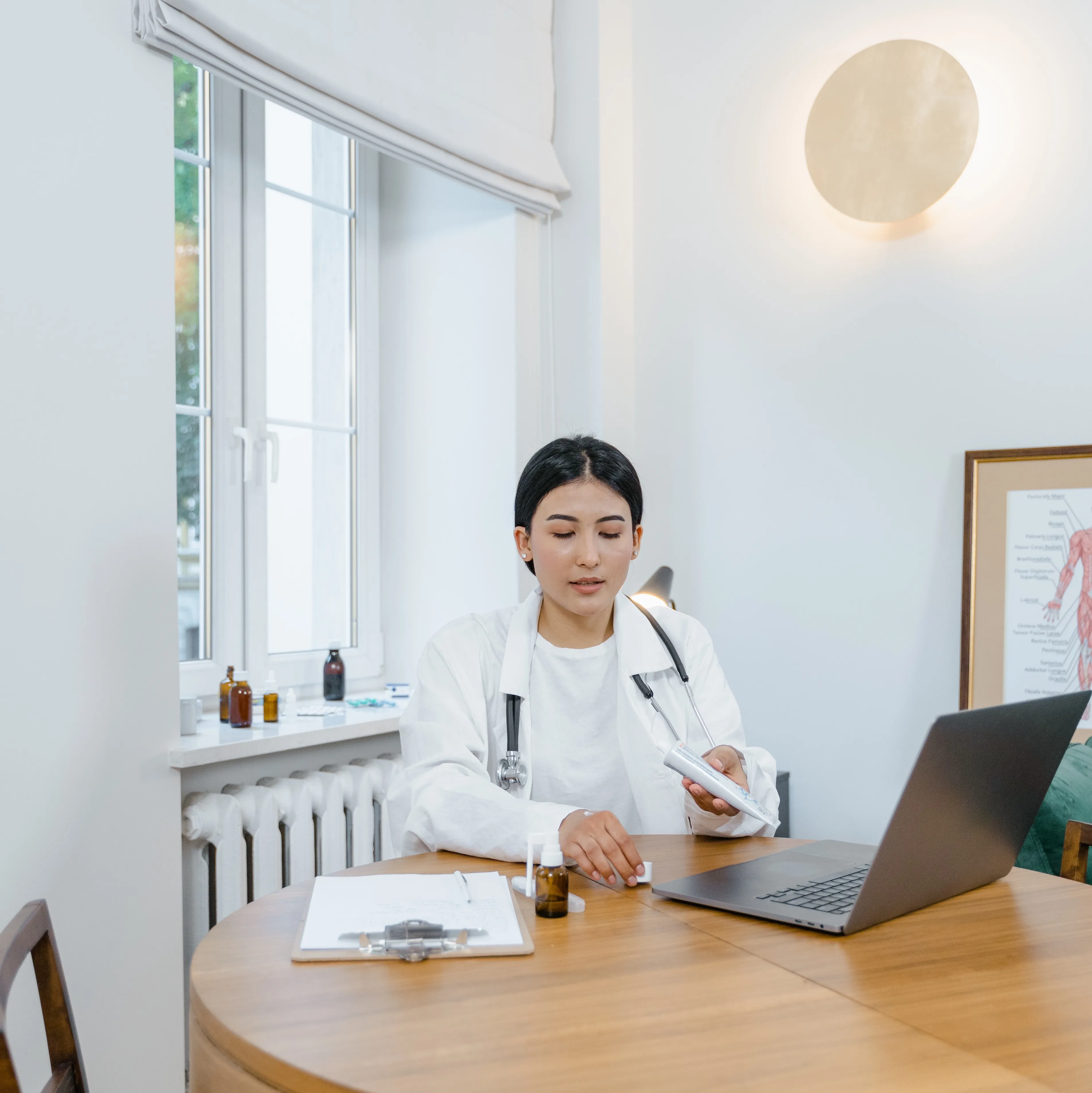 A female doctor with a computer writing a prescription